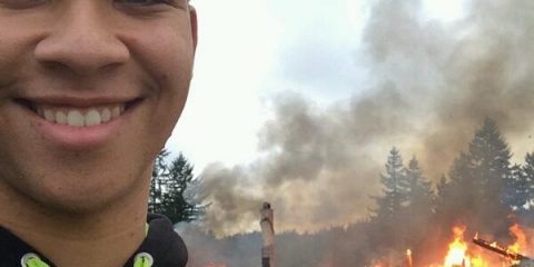 There's no reason to be smiling in this photo of a burning house in the background. #epicselfiefail